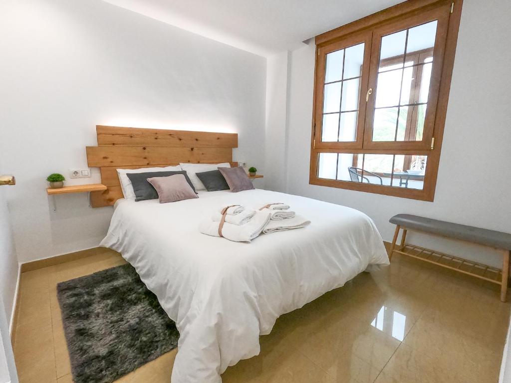 a bedroom with a white bed with two towels on it at Apartamento Altea Blanca in Altea