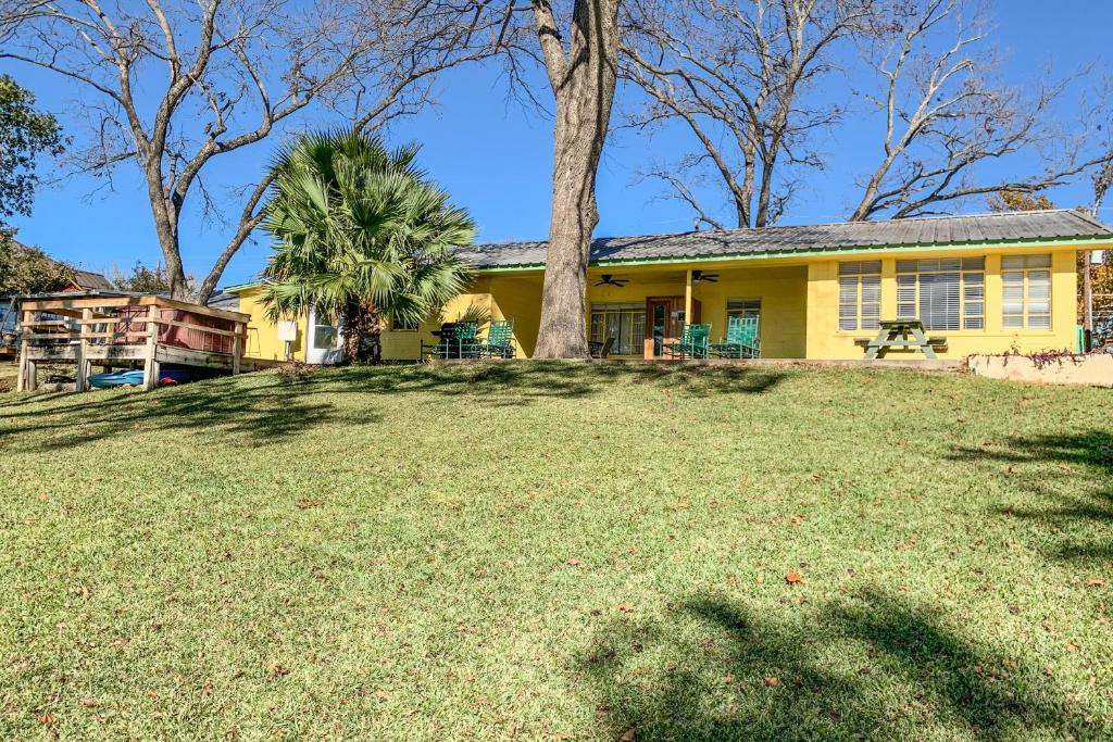 ein gelbes Haus mit einem Baum im Hof in der Unterkunft Green Harbor Lake House in Kingsland