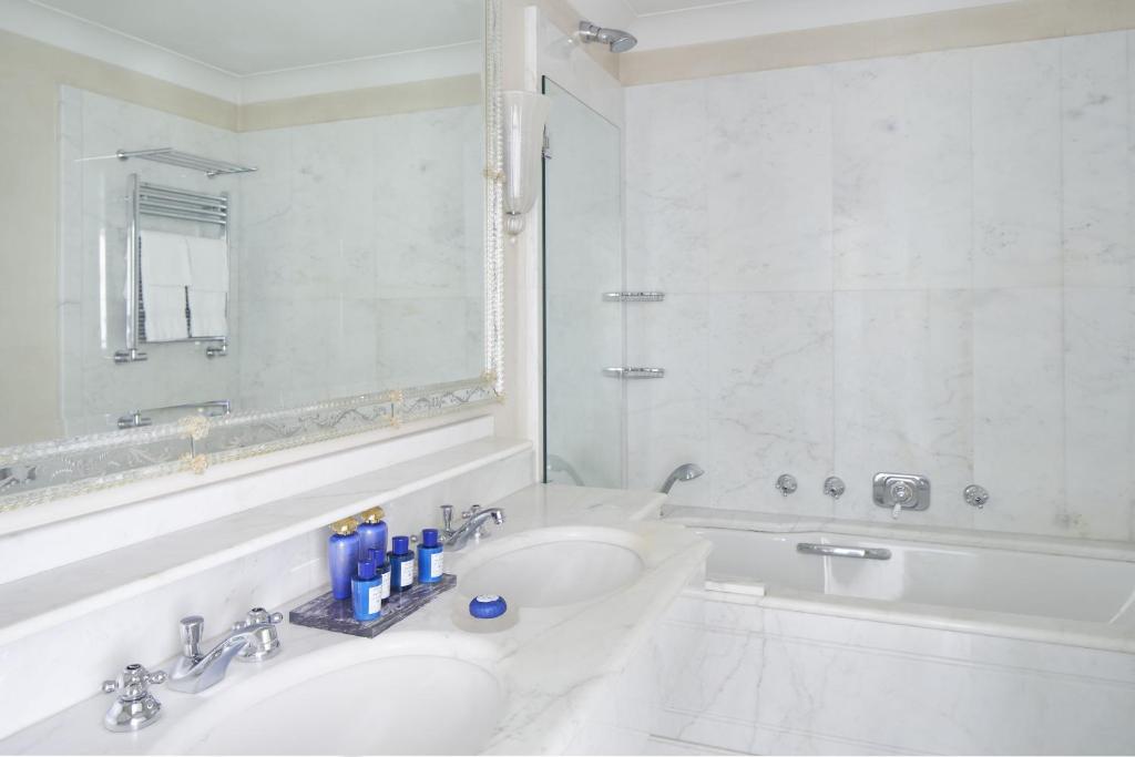a white bathroom with a tub and a sink at Hotel Cipriani, A Belmond Hotel, Venice in Venice