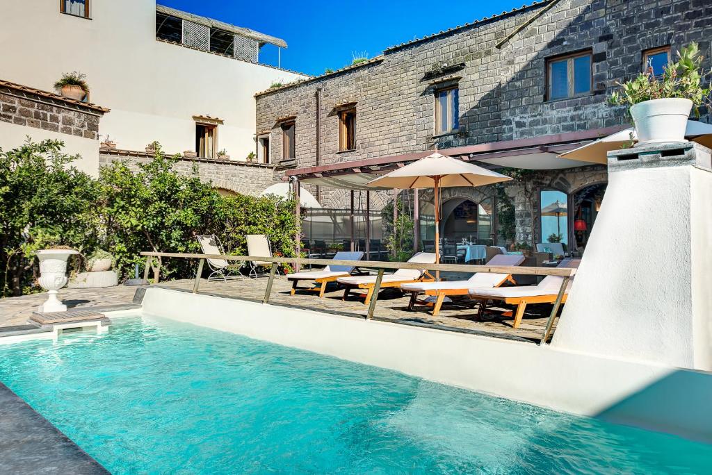 una piscina con mesas y sillas y un edificio en Lubra Casa Relax en Massa Lubrense
