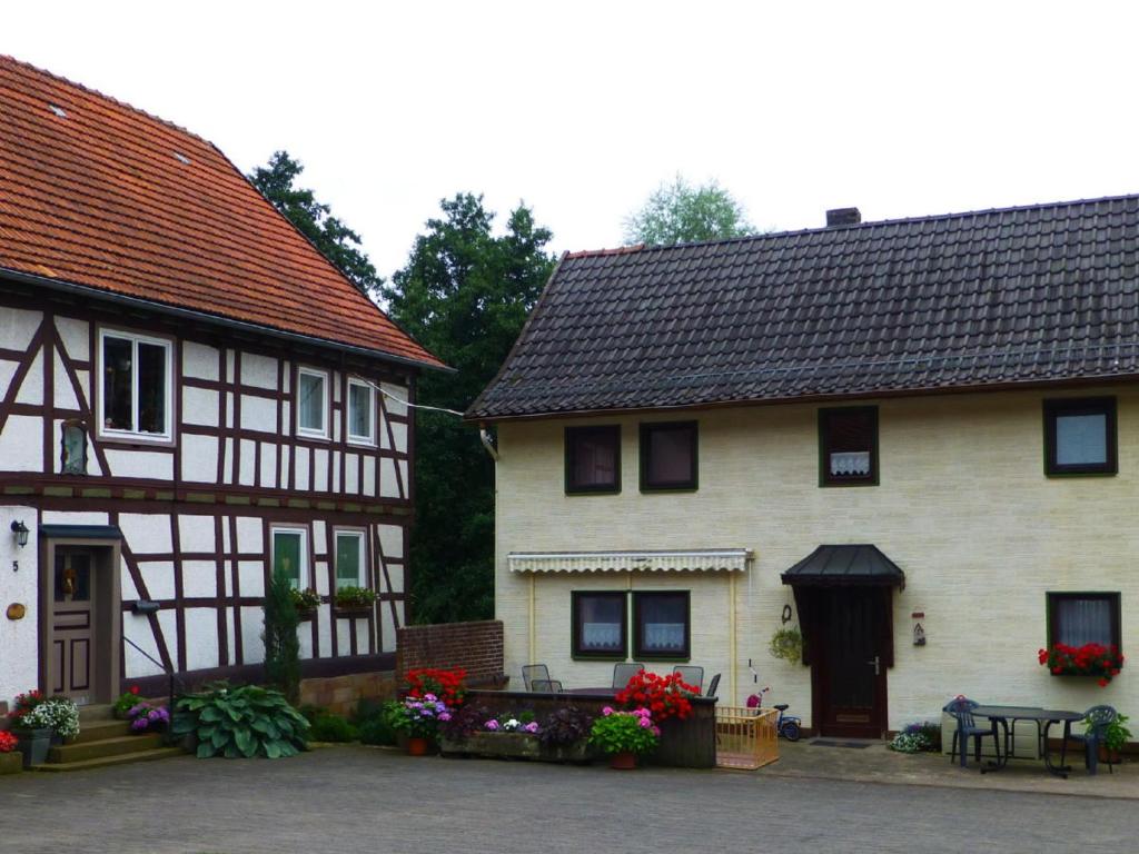 two old buildings with flowers in front of them at Ferienhaus Mahlertsmühle in Hofbieber