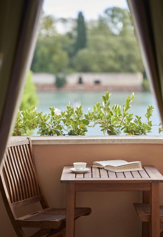 a table with a book and a cup and a book at Hotel Cipriani, A Belmond Hotel, Venice in Venice