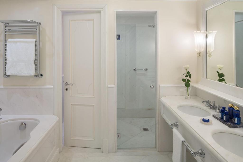 a white bathroom with a shower and a sink at Hotel Cipriani, A Belmond Hotel, Venice in Venice