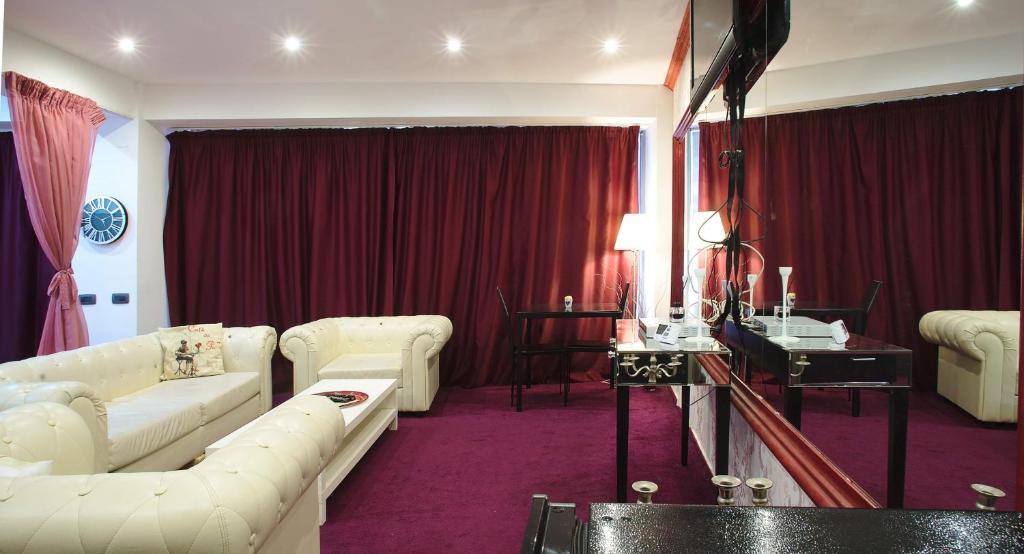 sala de estar con muebles blancos y cortina roja en Aparthotel Jolie, en Galaţi