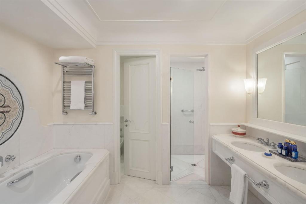 a white bathroom with a tub and a sink at Hotel Cipriani, A Belmond Hotel, Venice in Venice