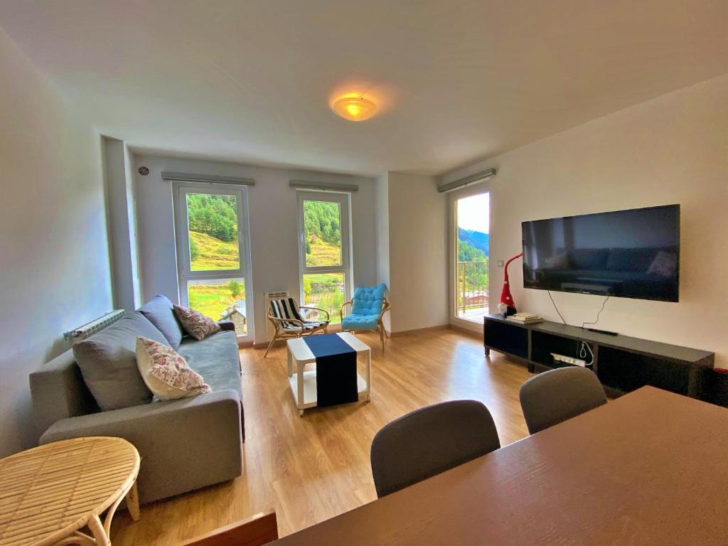 a living room with a couch and a flat screen tv at Ribasol 645, apartamento hasta 4 personas, Arinsal in Arinsal