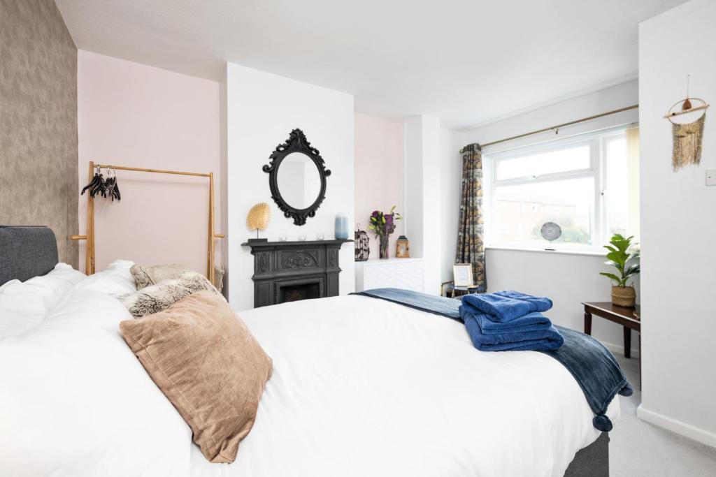 1 dormitorio con cama blanca y espejo en Pendicke Cottage, Southam, en Southam