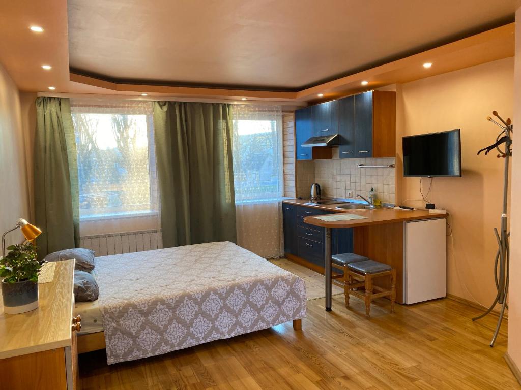 a bedroom with a bed and a kitchen with a desk at Rest in Palanga in Palanga