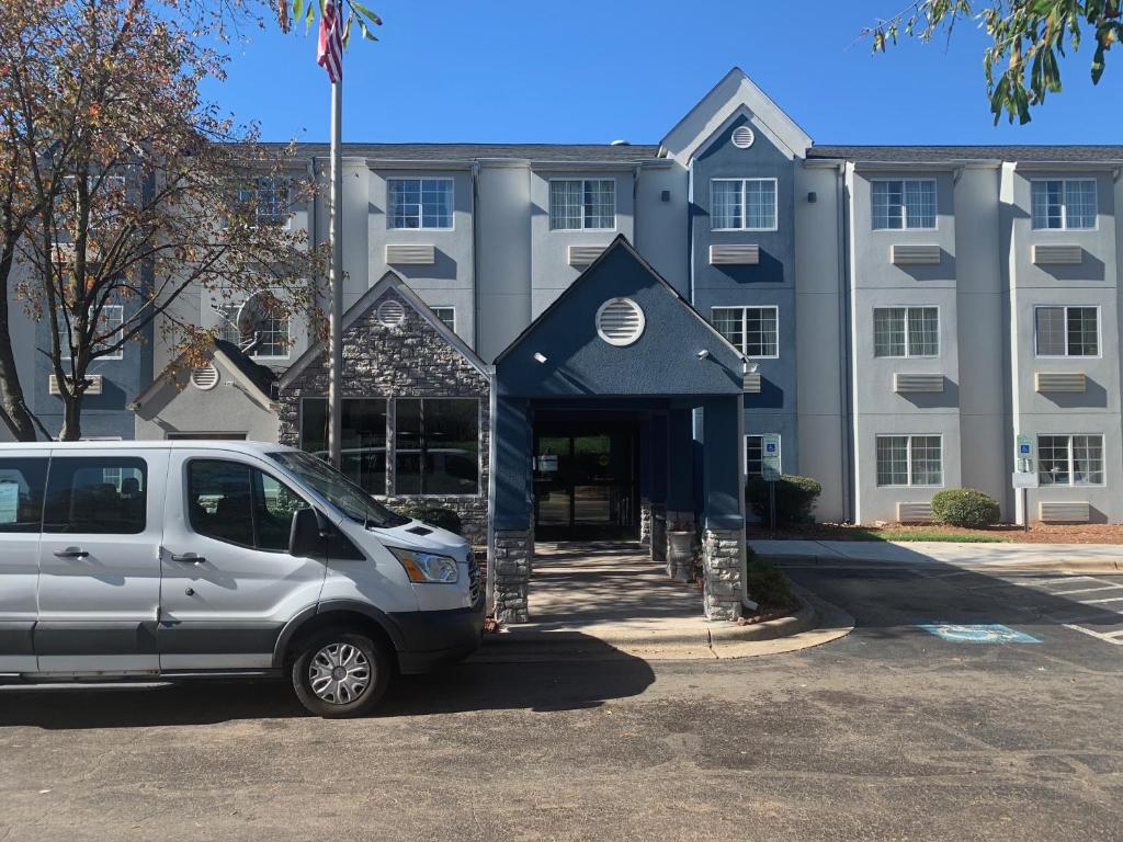 a van parked in a parking lot in front of a building at Microtel Inn by Wyndham Charlotte Airport in Charlotte