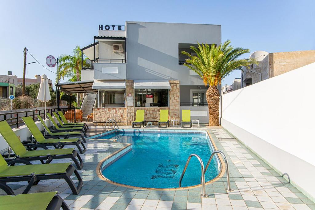 a pool with chaise lounge chairs and a hotel at ICandy Sol in Malia