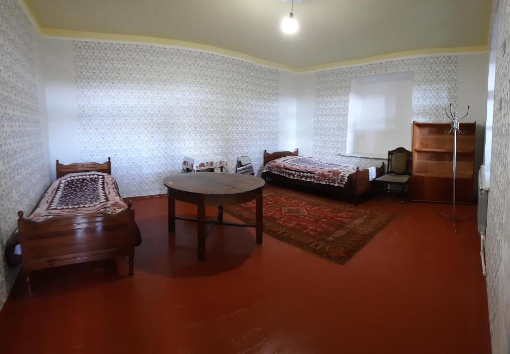 Zimmer mit 2 Betten und einem Tisch in der Unterkunft The Lichk Lodge in Lichkʼ