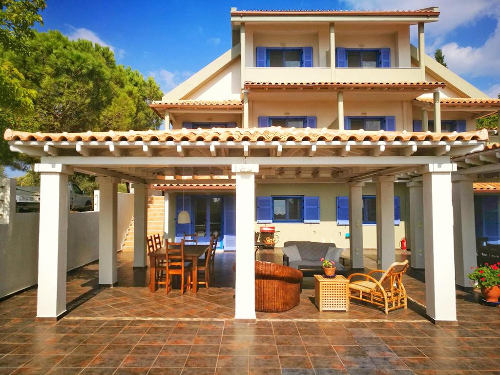 a pergola on a patio in front of a house at Olive Bay Hilltop Apartments Ammouliani in Ammouliani