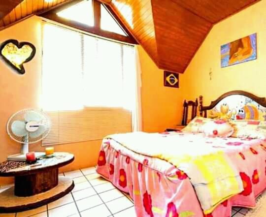 佛羅安那波里的住宿－Casa Hostel Mosaicos DyA，一间卧室配有一张床、一张桌子和一个窗户。