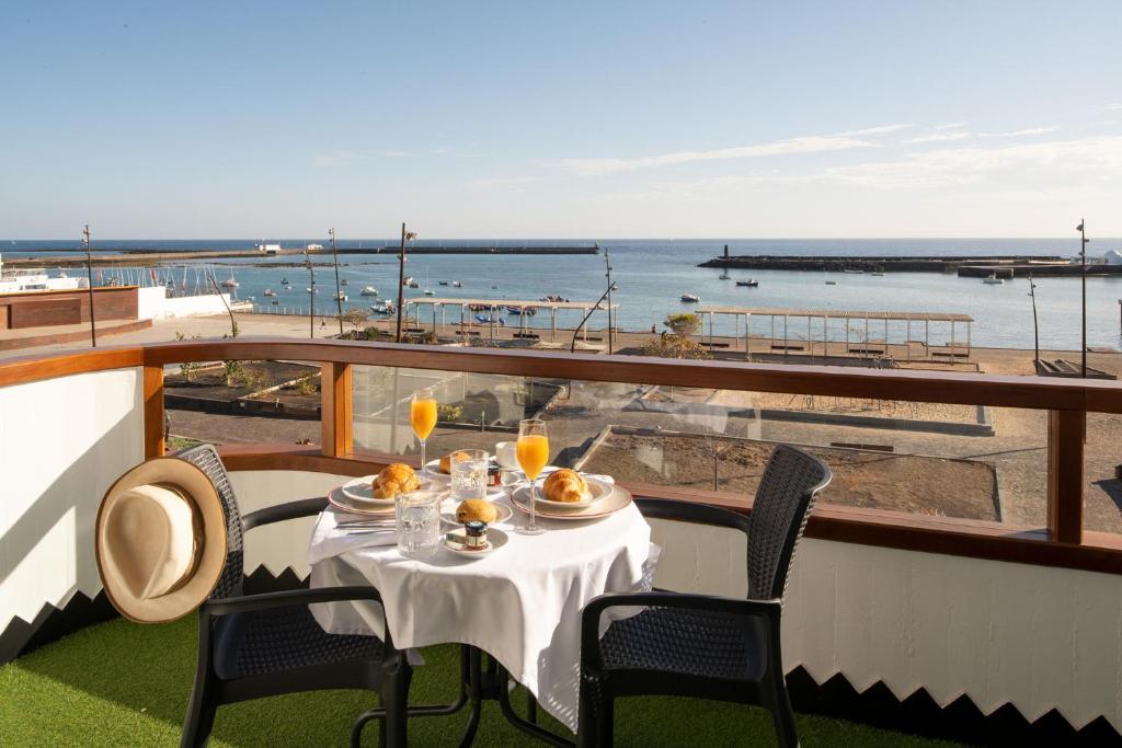 einen Tisch auf einem Balkon mit Meerblick in der Unterkunft Apartamentos Islamar Arrecife in Arrecife