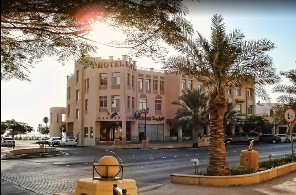 a building with a palm tree in front of a street at بفن للشقق المخدومة Puffin Serviced Apartments in Al Jubail