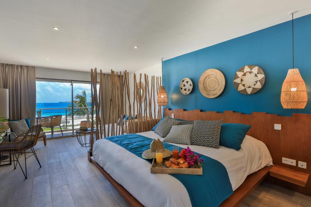a bedroom with a bed with a tray of fruit on it at Orient Beach Hotel in Orient Bay