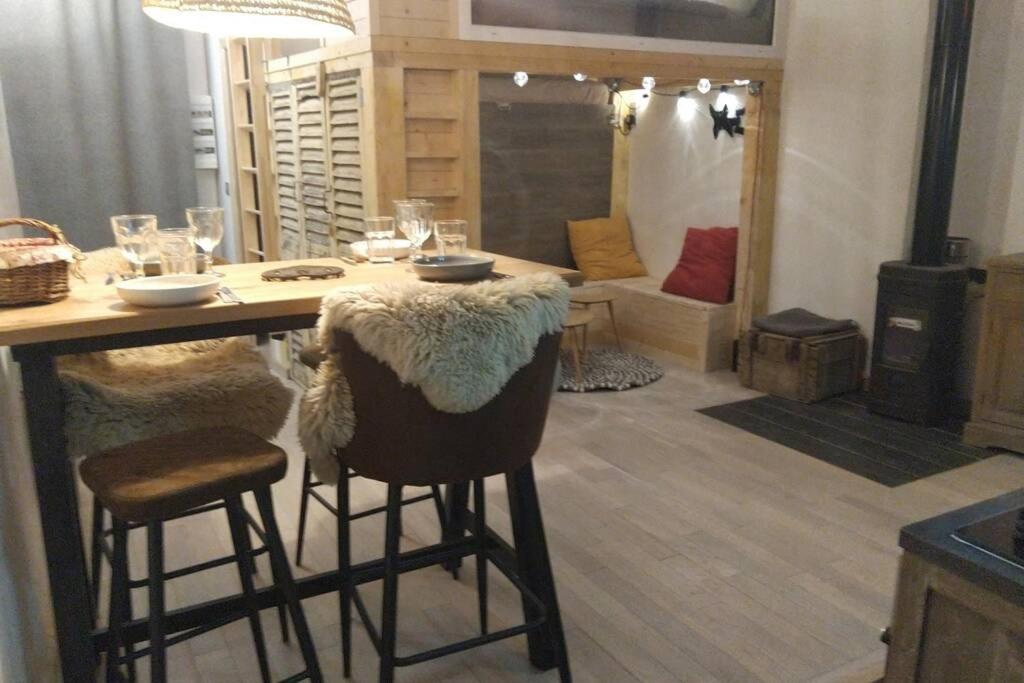 uma cozinha com uma mesa com bancos e uma sala de jantar em Chaleureux petit appartement de 4 couchages em Saint-Étienne-de-Tinée