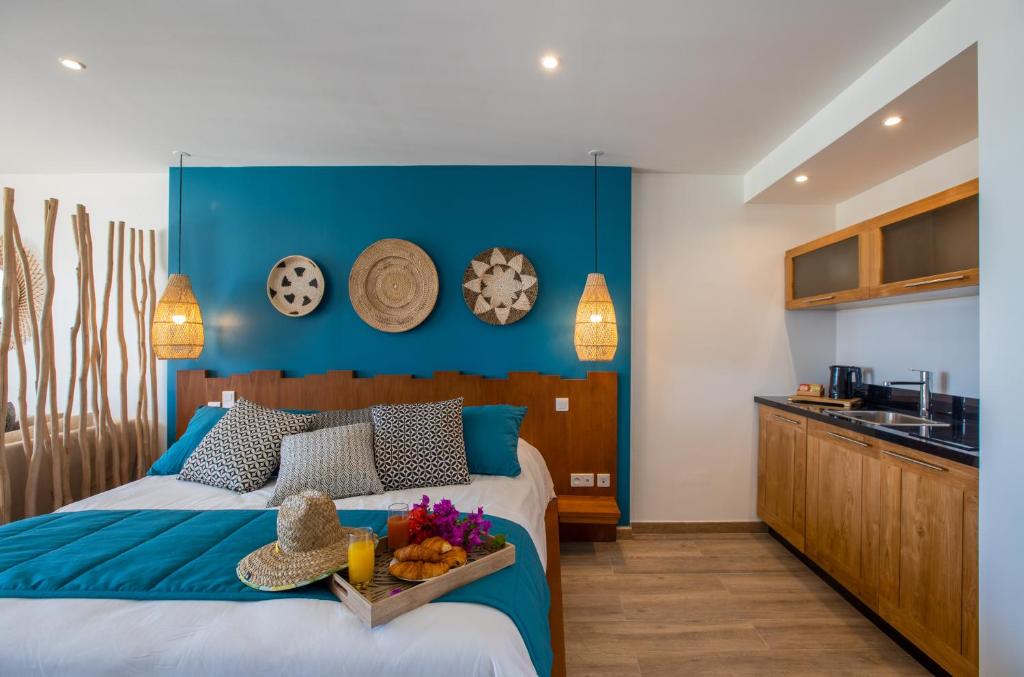a bedroom with a bed with a blue wall at Orient Beach Hotel in Orient Bay