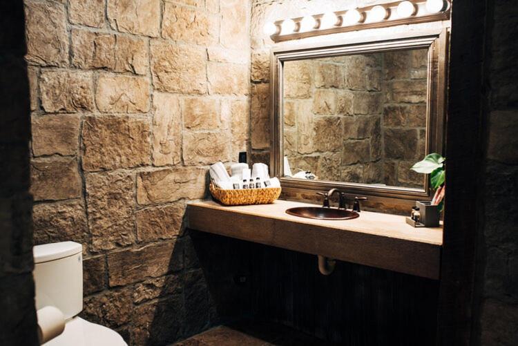 a stone bathroom with a sink and a mirror at The Inn at Zaca Creek in Buellton
