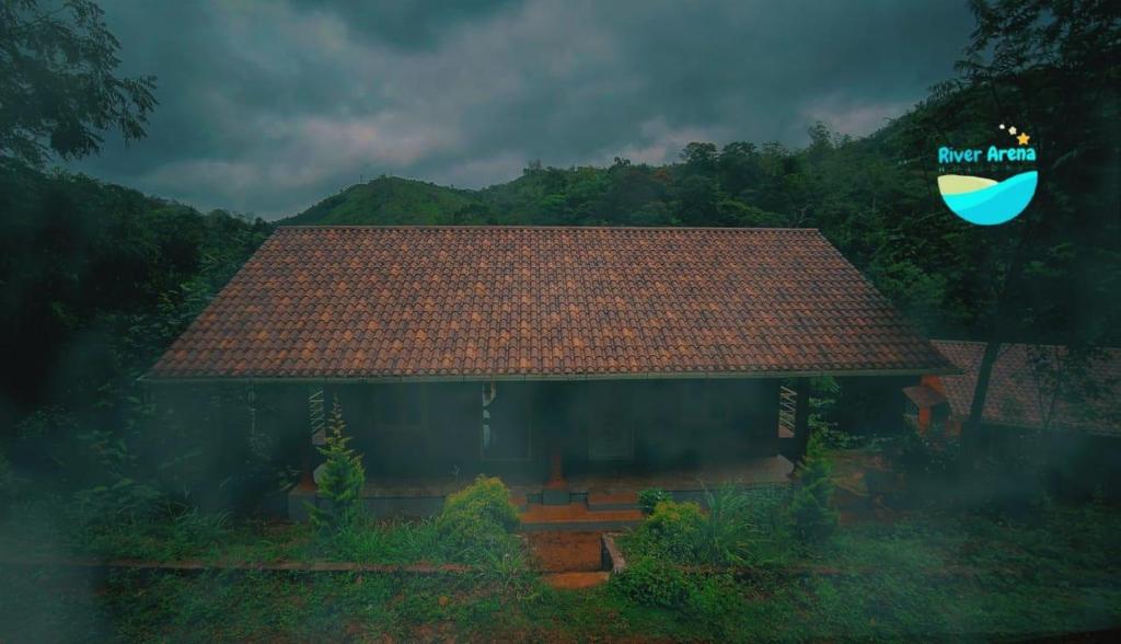 a house with a roof with a logo on it at River Arena Holidays in Vagamon