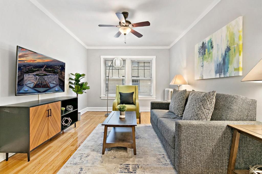 ein Wohnzimmer mit einem Sofa und einem TV in der Unterkunft 1-bedroom Cozy & Modish Apt - Marshfield W2 rep in Chicago