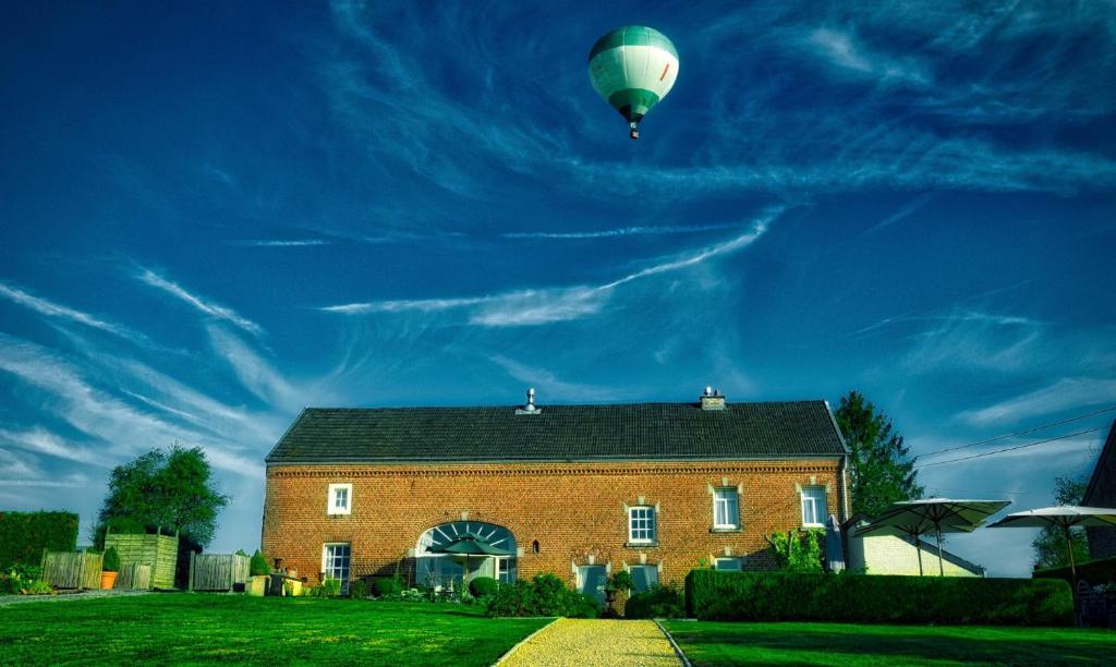 ein Heißluftballon fliegt über ein Haus in der Unterkunft La Closerie in Durbuy