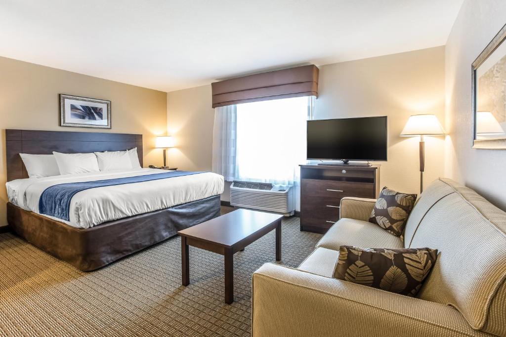 ein Hotelzimmer mit einem Bett und einem TV in der Unterkunft MainStay Suites Cartersville in Cartersville