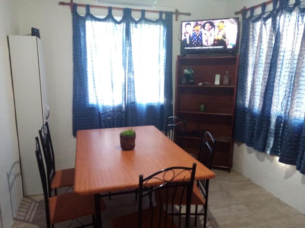 uma sala de jantar com uma mesa de madeira e uma televisão em CandeYaz em Piriápolis