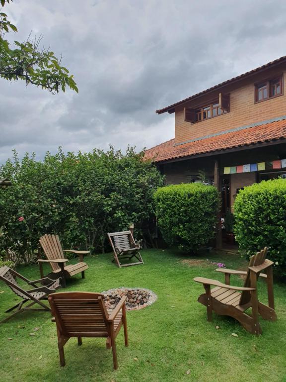 a yard with chairs and a fire pit in front of a house at Reino Solar in Cunha