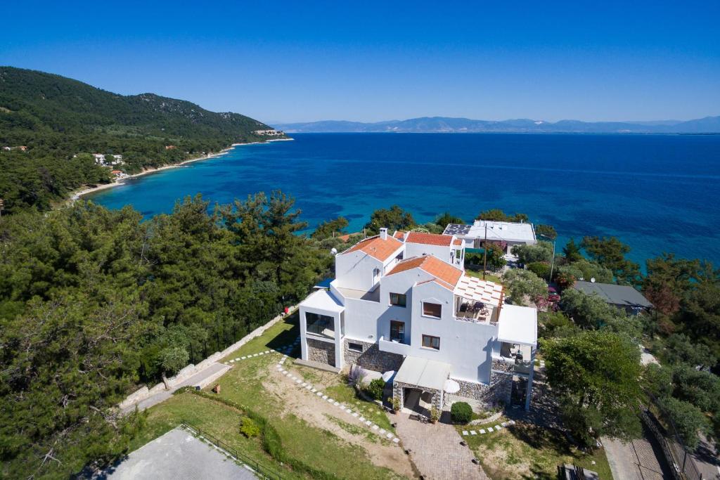 an aerial view of a white house on a hill next to the ocean at Villa Victoria by La Scala Beach in Limenas