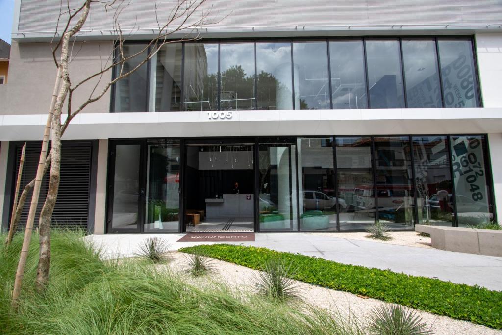 VNH Residencial by Audaar في ساو باولو: مبنى مكتب بأبواب زجاجية وساحة