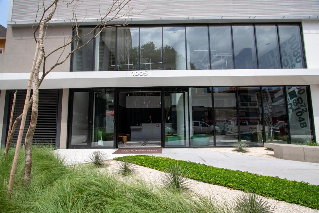 an office building with glass doors and a courtyard at VNH Residencial by Audaar in São Paulo