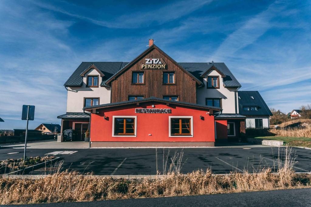 un grand bâtiment avec un rouge et un blanc dans l'établissement Penzion Zita, à Boží Dar