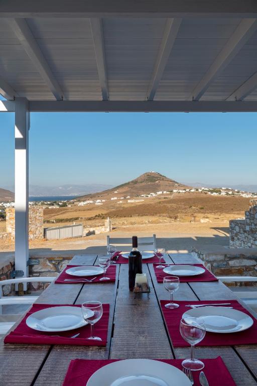 a long wooden table with red napkins and wine glasses at Stone Villa Kontiani - Red Villa in Dhragoulás