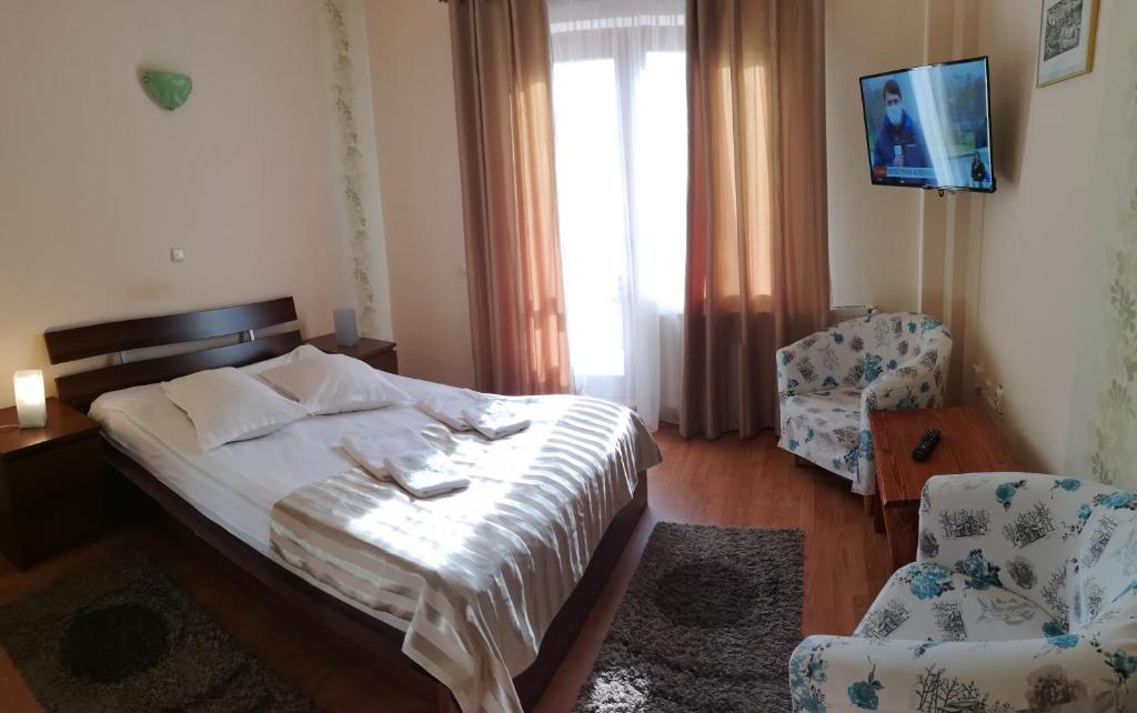 1 dormitorio con 1 cama, 1 silla y TV en Pension Bittner en Brasov