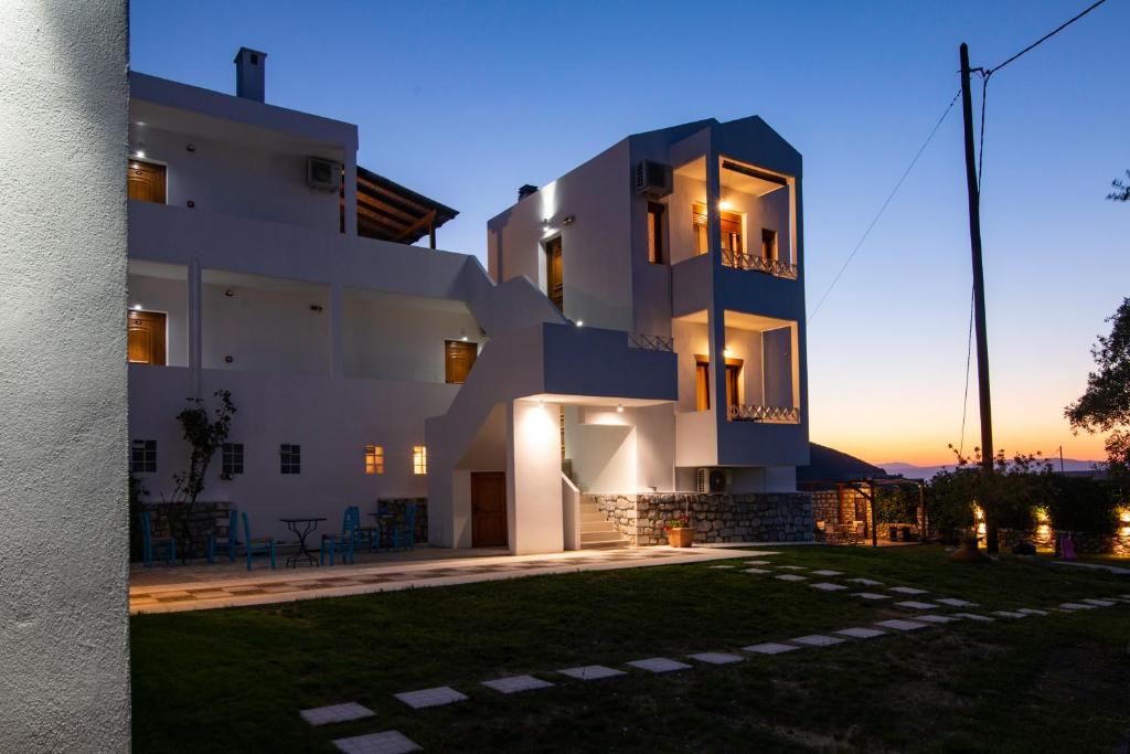 a large white building with a yard in front of it at Villa Victoria by La Scala Beach in Limenas