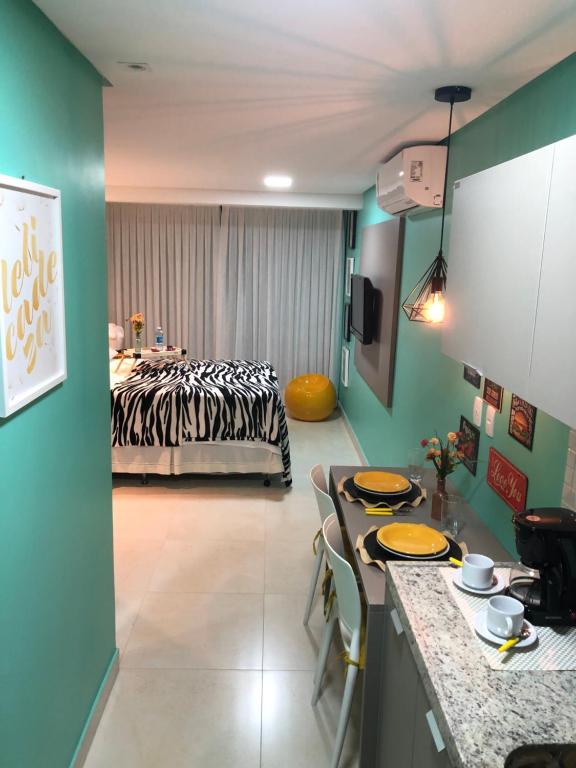 Habitación con cama y mesa con sillas. en Magnífico Flat no melhor de Manaíra - Apart Hotel, en João Pessoa