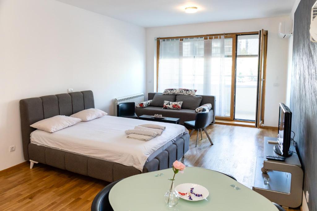 een woonkamer met een bed en een bank bij Don Vito in Belgrado