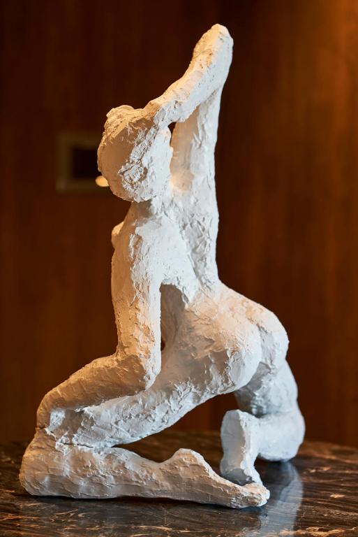 a white sculpture of a person dancing on a table at Root Redrock Yalıkavak in Yalıkavak