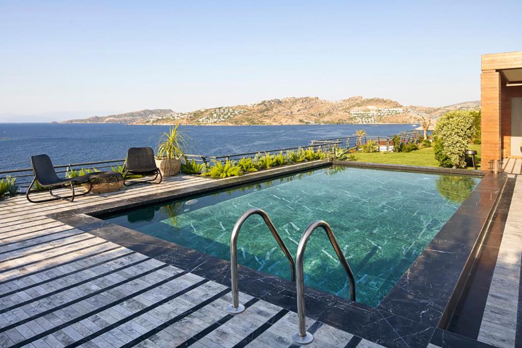 a swimming pool with a view of the water at Root Redrock Yalıkavak in Yalıkavak