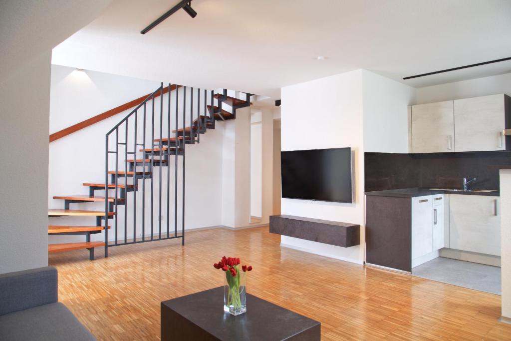 a kitchen and living room with a staircase in a house at Helles Maisonette-Apartment am Aalener Stadtpark in Aalen