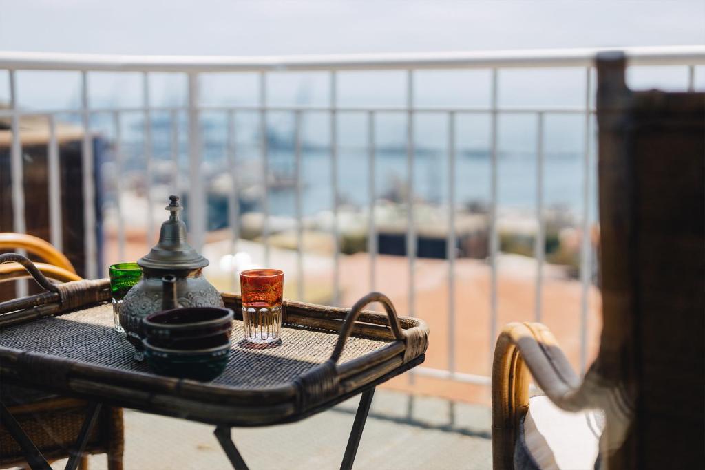 Una mesa con dos vasos y una bebida en un balcón. en Casablu Hotel, en Valparaíso