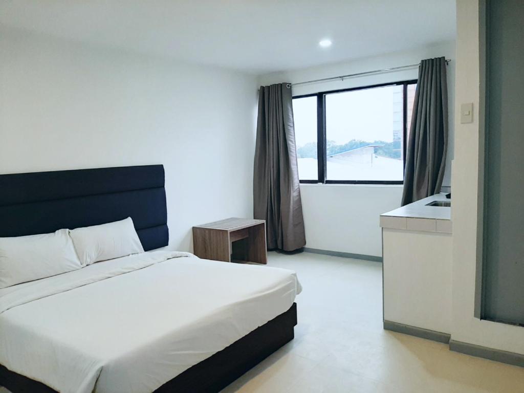 a bedroom with a bed and a bathroom with a window at Anex Hotel near US Embassy in Manila