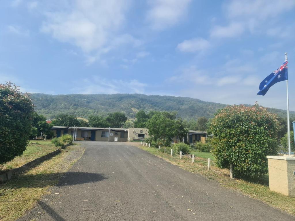 Murrurundi的住宿－山谷美景汽車旅館，建筑物前有旗帜的空路
