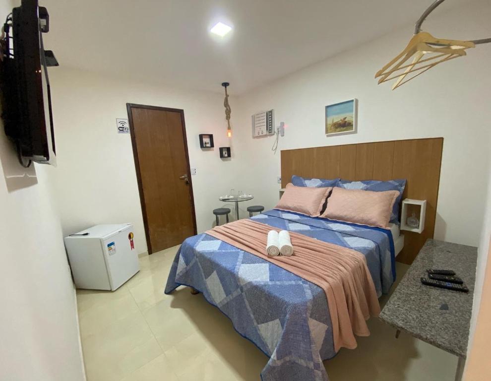 um quarto com uma cama com um edredão azul em Suites Brisa e Estrela e Gruta na Praia do Forte