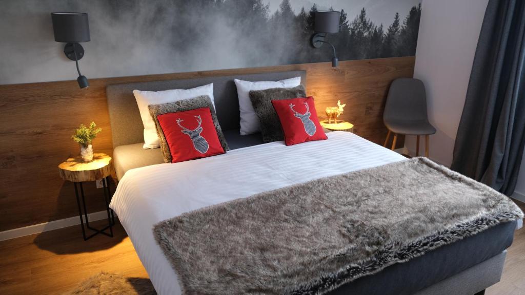 um quarto com uma cama grande e almofadas vermelhas em MarleSKI & Sauna em Szczyrk