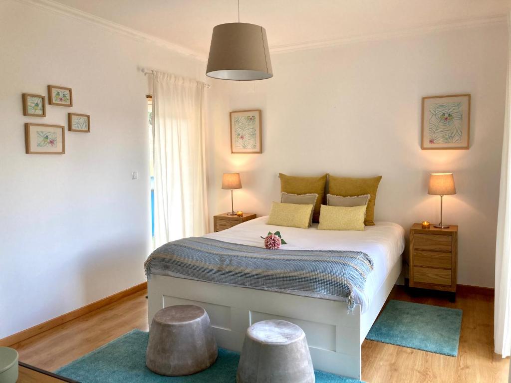 een slaapkamer met een bed met twee krukken erin bij SUITE LIKE SWEET in Torres Vedras