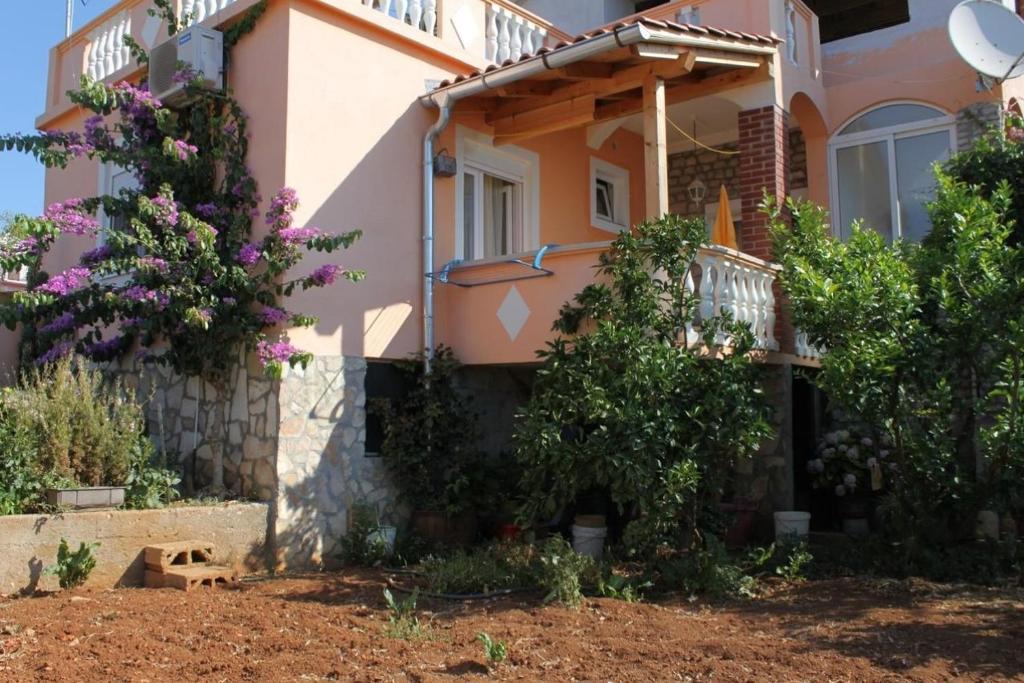 a pink house with flowers in front of it at Apartments Ralje - 100m from the sea & free parking in Sali