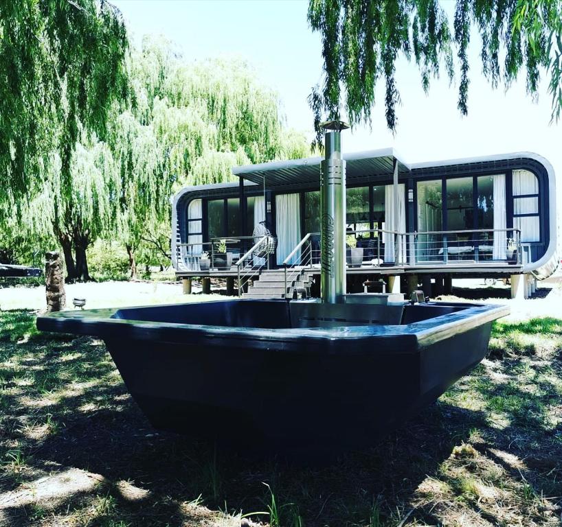 a boat sitting in the grass in front of a house at Kingsbrook Pods in Clarens