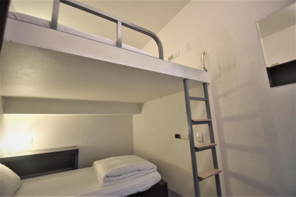 a bunk bed in a small room with a ladder at Inn Cube - Ximen in Taipei